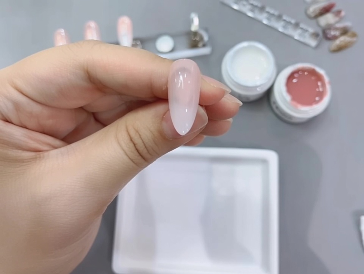 Ein Nageltip mit dem fertigen Farbverlauf wird unter der Lampe ausgehärtet.