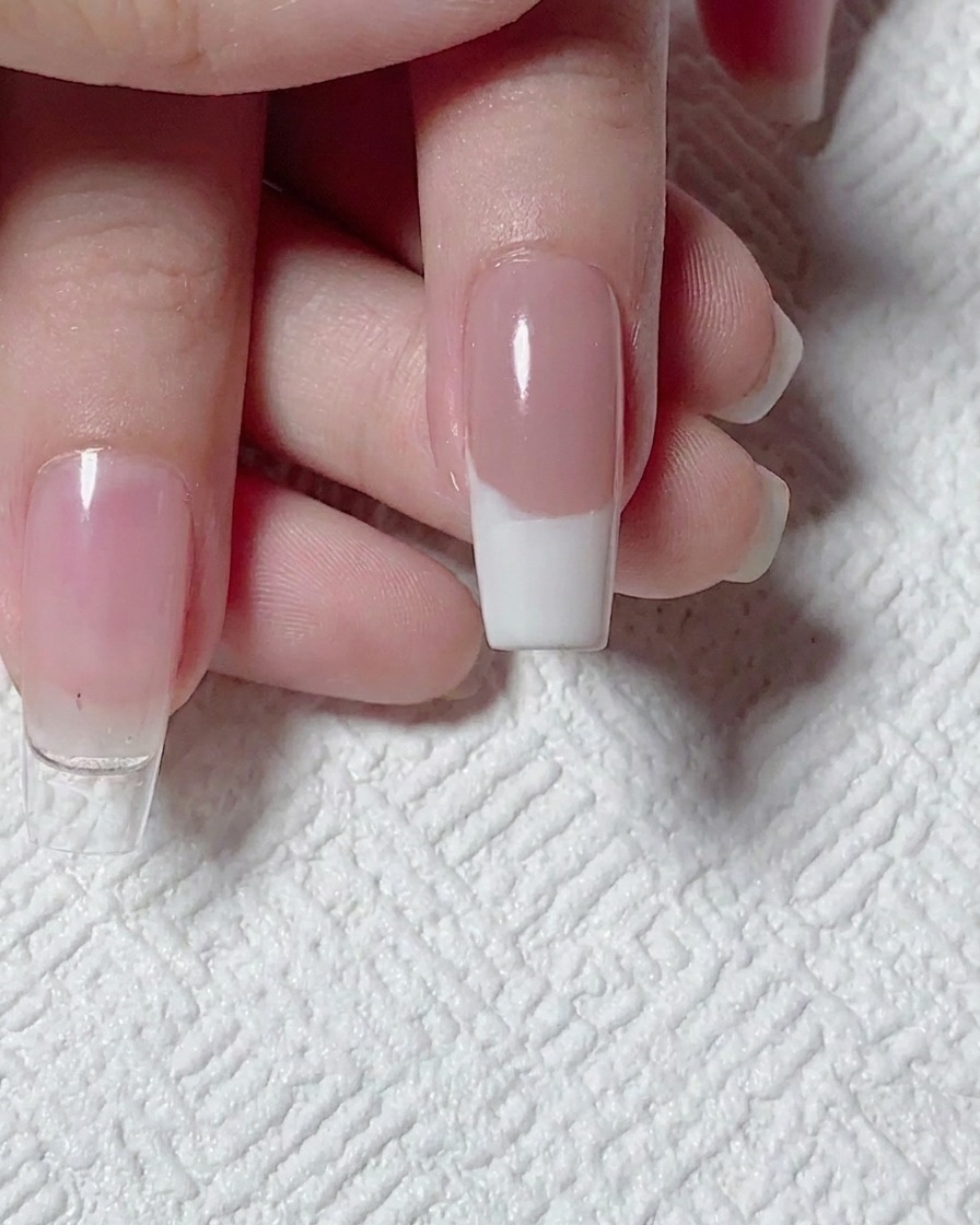Draufsicht auf ein fertiges weißes French-Spitzen-Design auf einer Nude-Basis, bereit für die Nagelkunst.