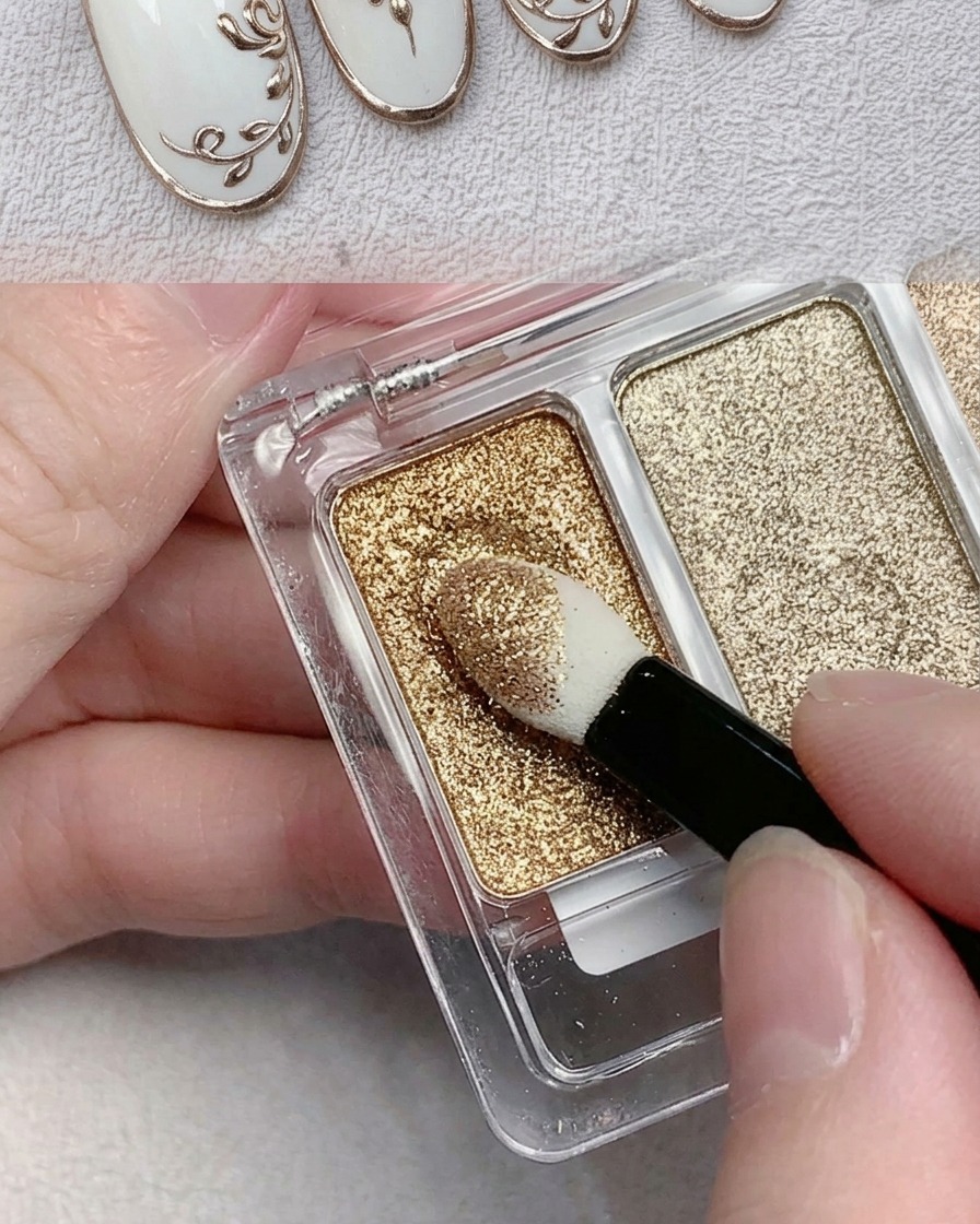 Ein Applikationsschwamm nimmt goldenes Chrompuder von einer Palette auf.