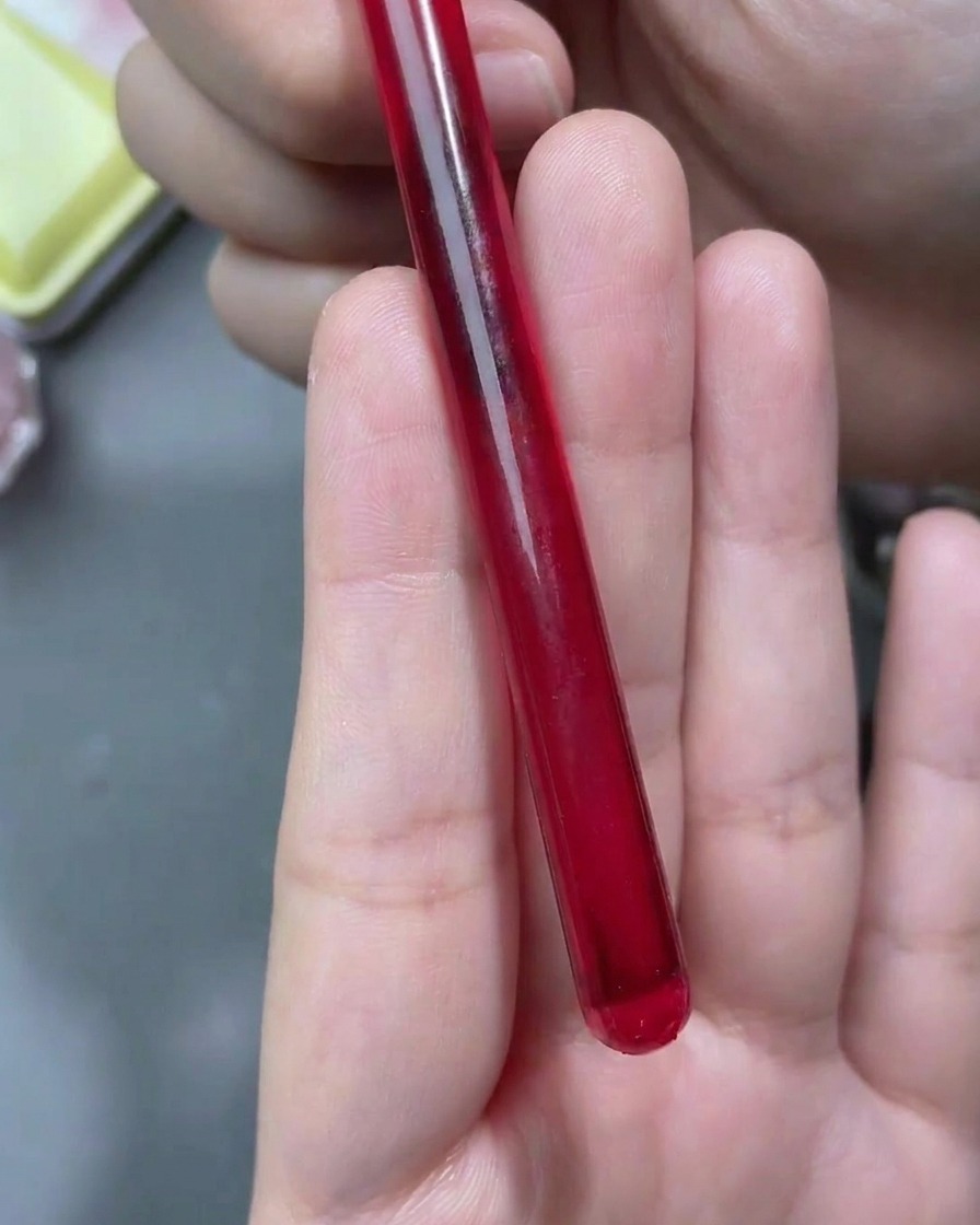 Ein feiner Liner-Pinsel zeichnet weiße Rosenumrisse auf einen mattierten Nagel.