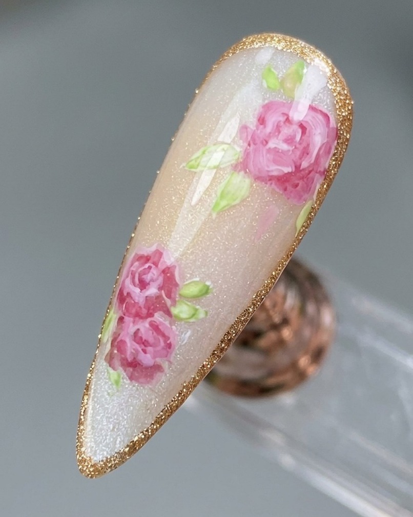 Nahaufnahme eines fertigen Rosen-Designs mit einer feinen, schimmernden Platin-Gel-Umrandung.