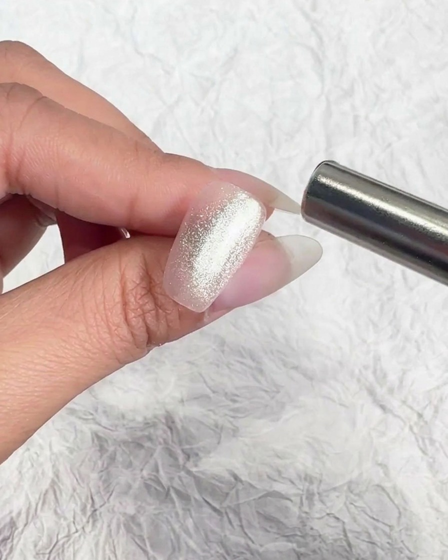 Ein magnetisches Werkzeug wird nah an den Nagel gehalten, um die Partikel zu bewegen.