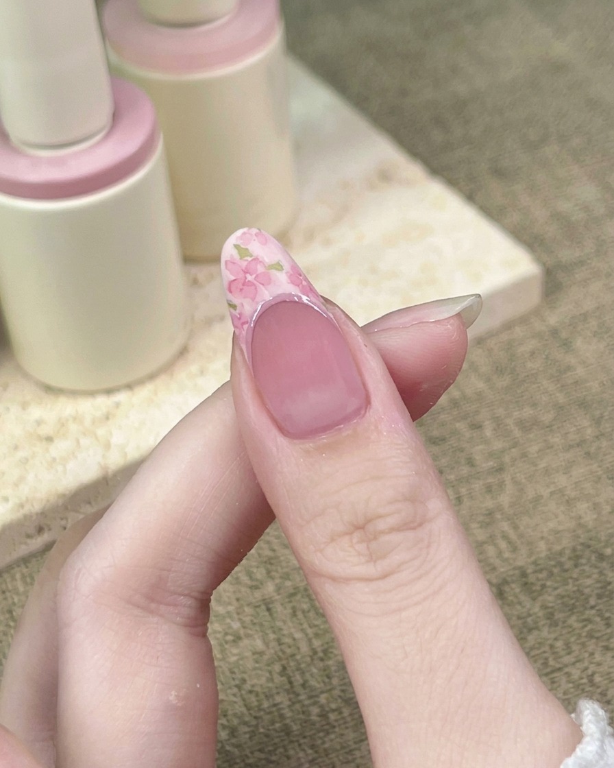 Eine Nahaufnahme zeigt einen Liner-Pinsel, der eine dunklere rosa Linie entlang der Kurve der French-Smile-Line nachzieht.