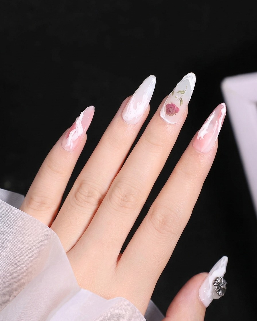 Nahaufnahme der unteren Blütenblätter, die dem weißen Gel-Rosendesign auf dem Nagel hinzugefügt werden.