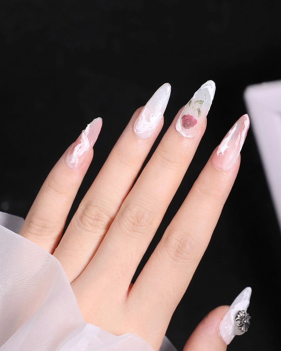 Ein kleiner Detailpinsel trägt einen transparenten roten Gel-Farbton auf den oberen Bereich einer weiß umrandeten Rose auf.