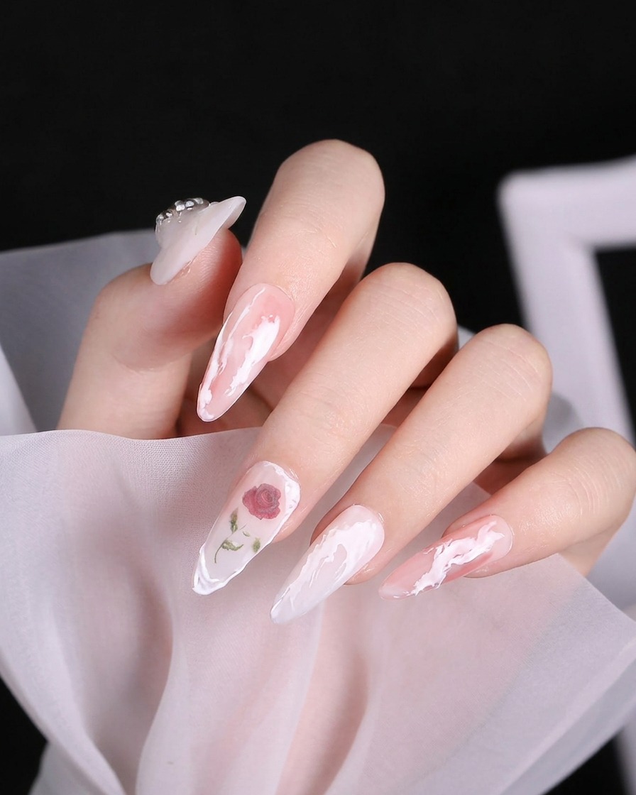 Ein Detailpinsel konzentriert eine tiefere rote Farbe in der Mitte eines Rosen-Nageldesigns.