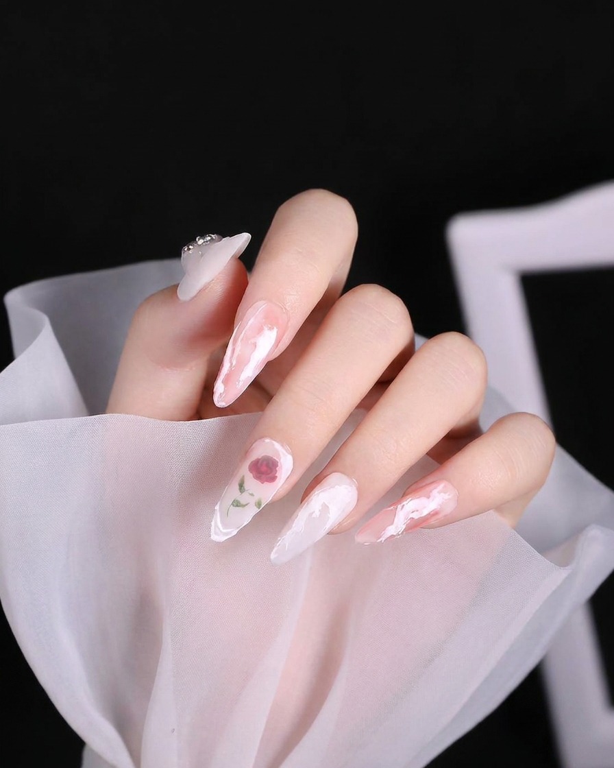 Ein Nail-Art-Pinsel trägt einen dicken, texturierten weißen Gel-Swirl auf den Nagelhautbereich eines Nagels auf.