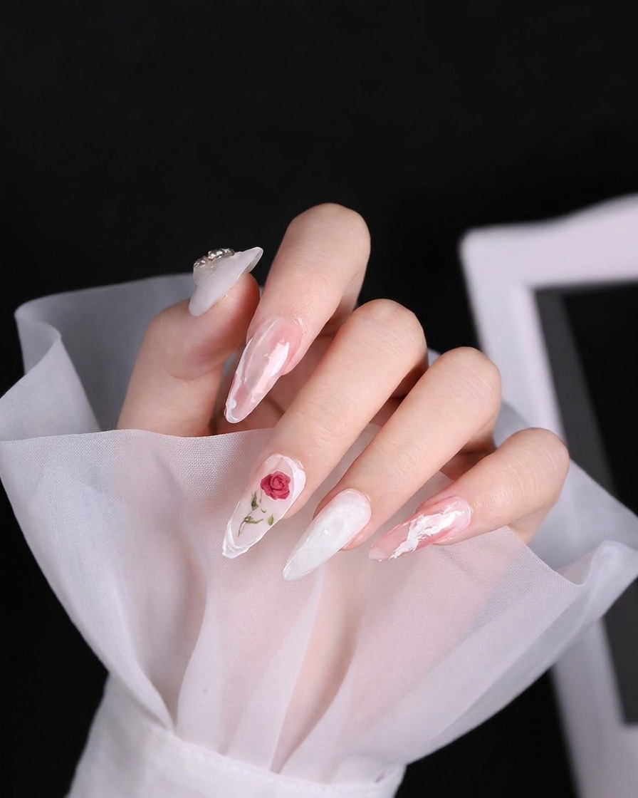 Nahaufnahme eines Nagelpinsels, der eine dicke, texturierte weiße Linie aus 3D-Gel auf einen hellrosa Nagel aufträgt.