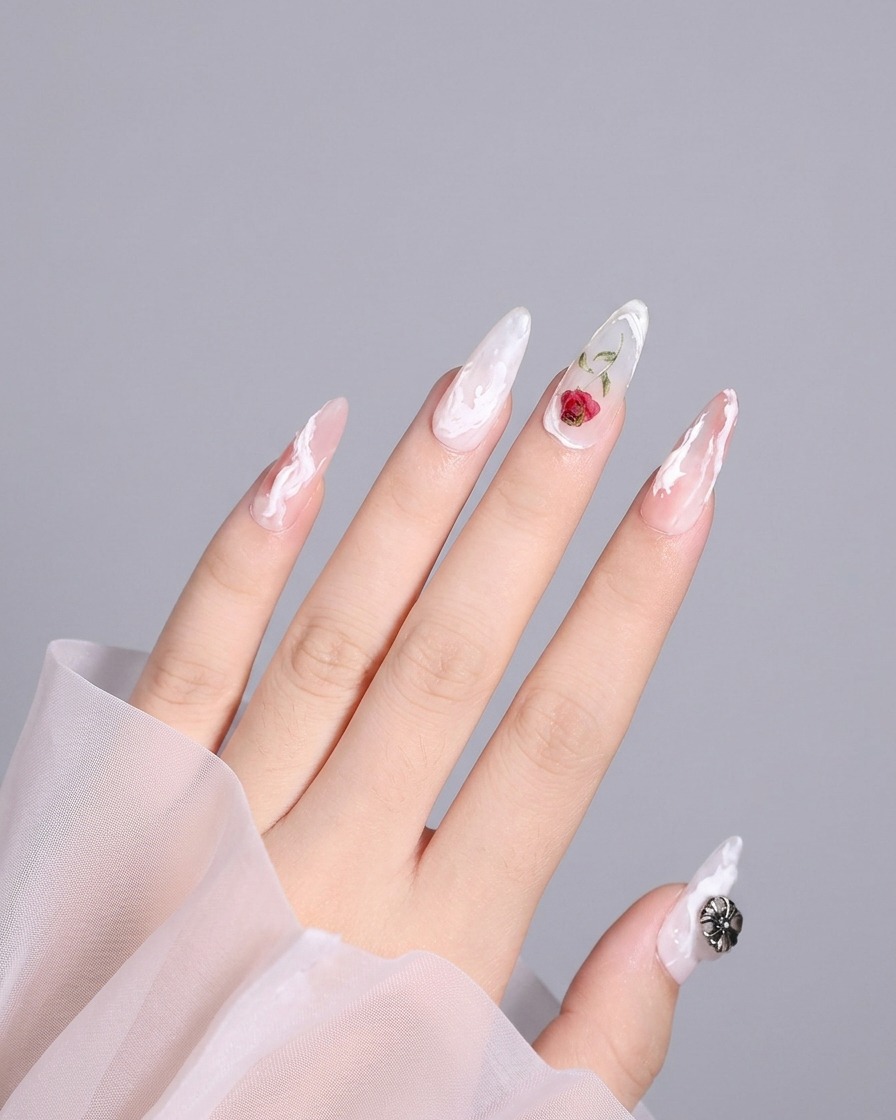 Detaillierte Aufnahme eines Daumennagels mit einem fertigen 3D-Design, einschließlich eines weißen Swirls in der Nähe der Kante.