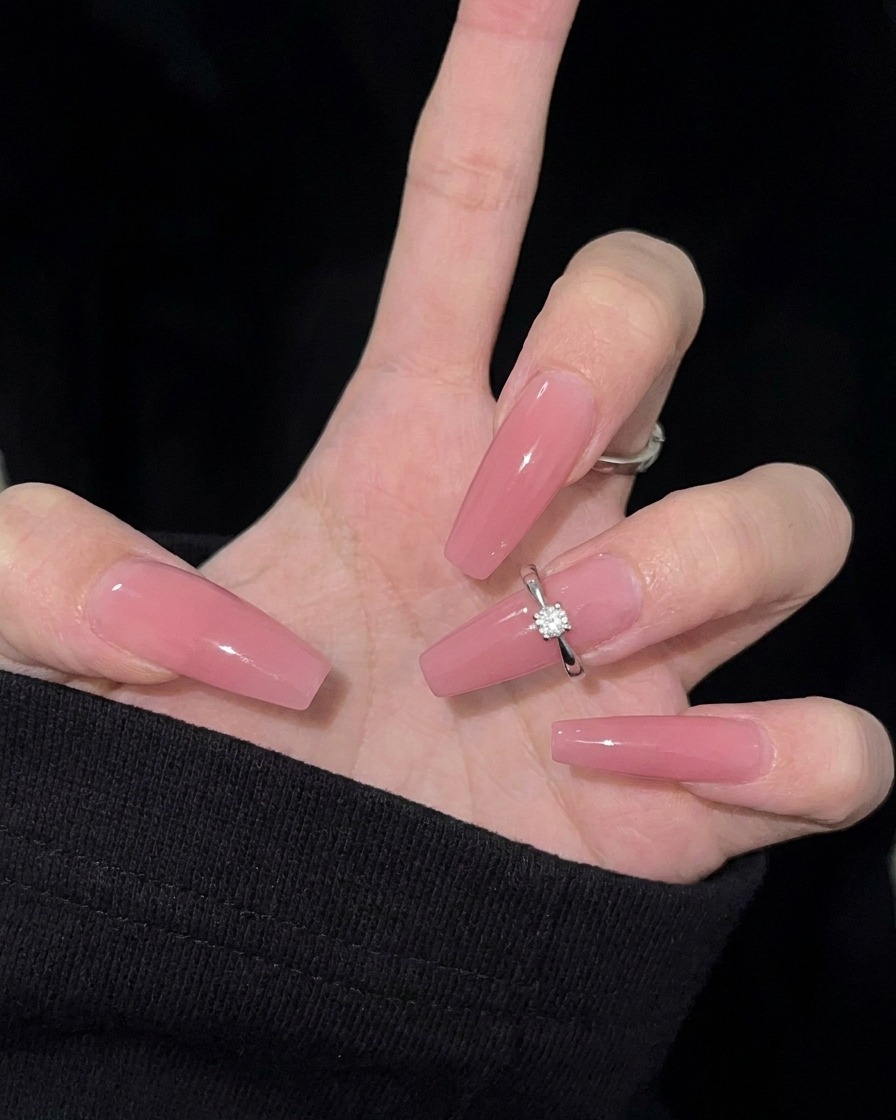 Nahaufnahme einer Nagelfeile, die verwendet wird, um den Rand eines Naturnagels in eine Mandelsilhouette zu formen.