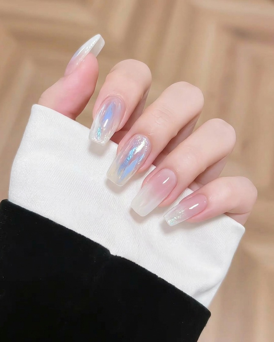 Ein kleiner Pinsel trägt einen konzentrierten Klecks blaues Pigment auf einen Nagel auf, um den Verlauf zu intensivieren.