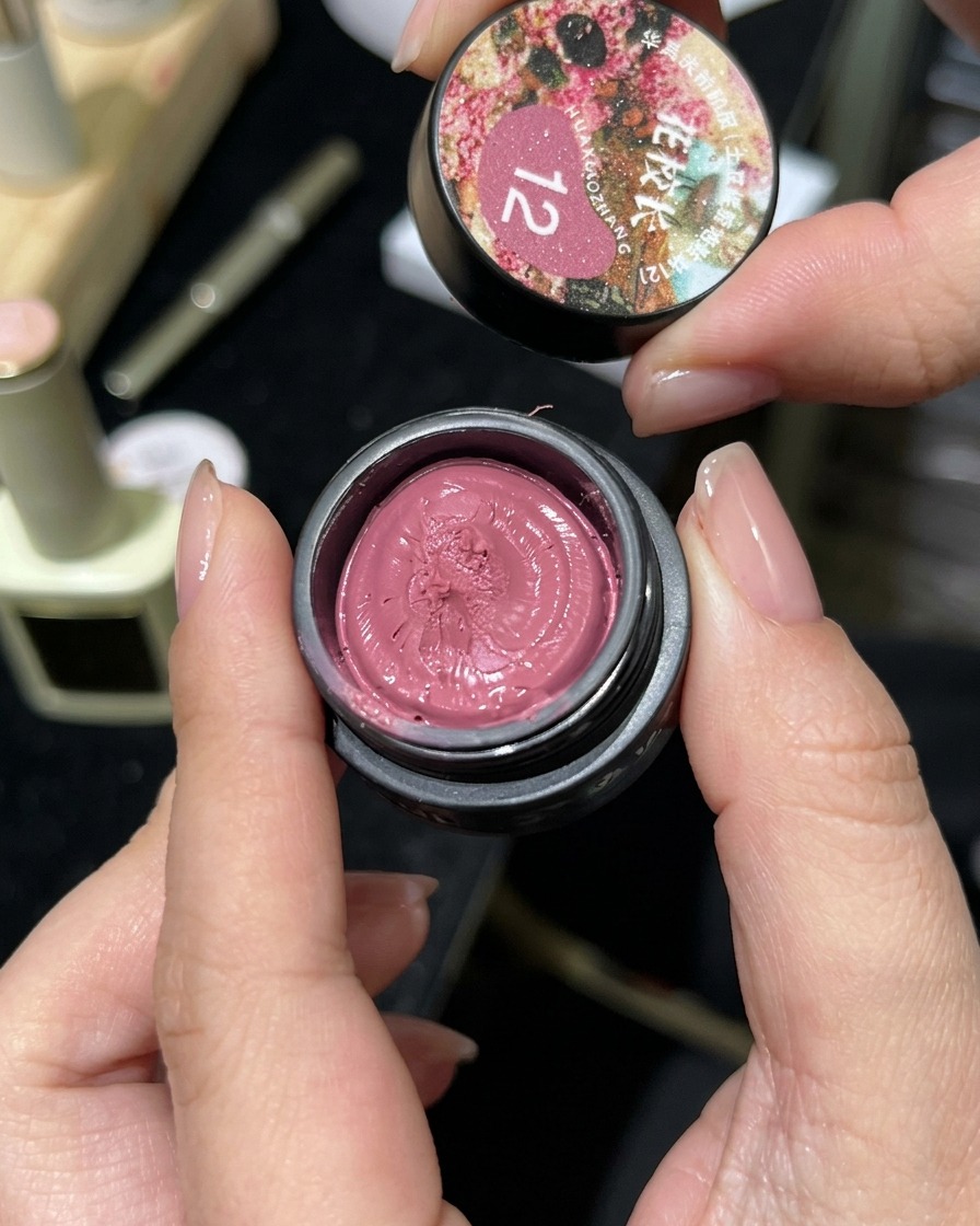 Ein kleiner Tiegel mit rosa Cat-Eye-Magnetgel wird geöffnet und zeigt die knetartige Textur.