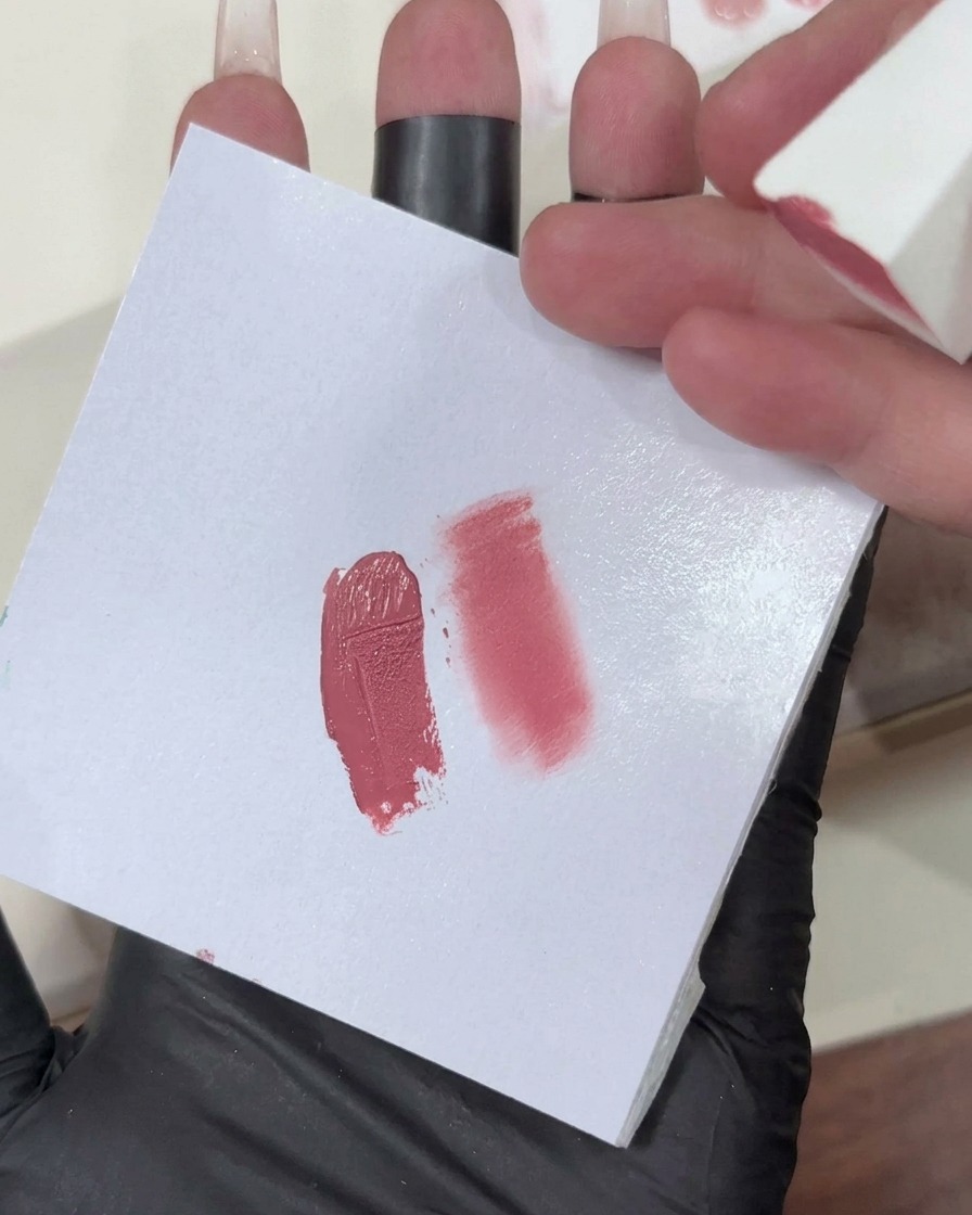 Ein Make-up-Schwamm mit einem hellrosa Gel-Verlauf wird auf die Nagelspitze aufgetragen.