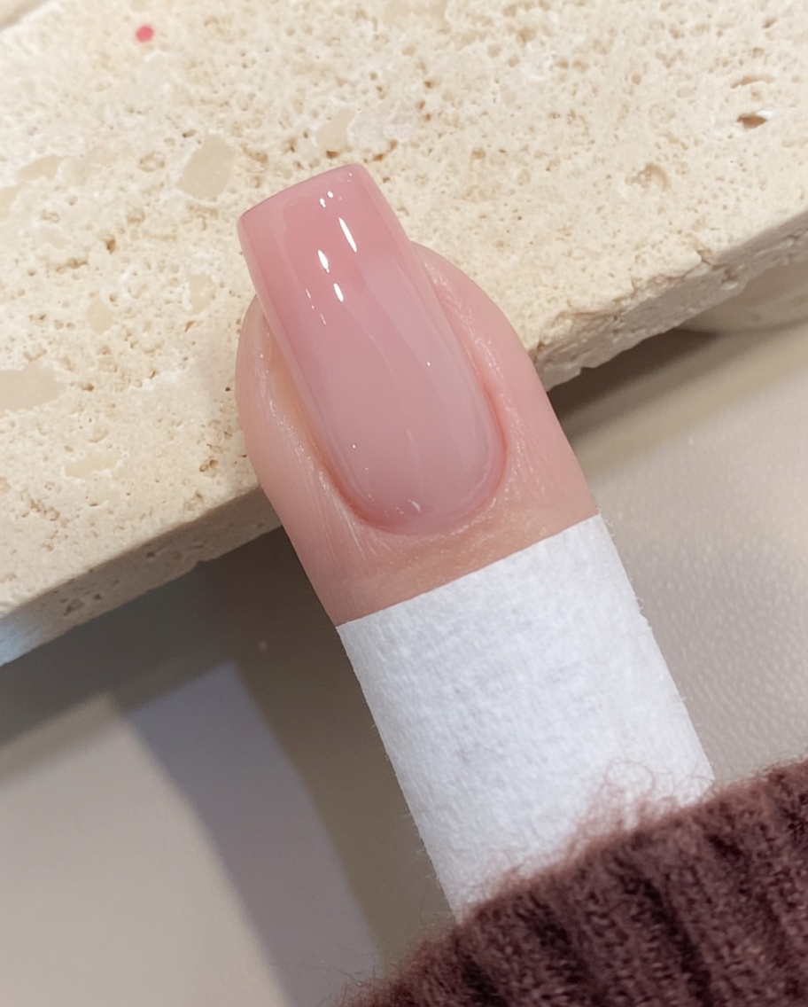 Ein fusselfreies Tuch entfernt die klebrige Schicht von einem ausgehärteten Gelnagel.