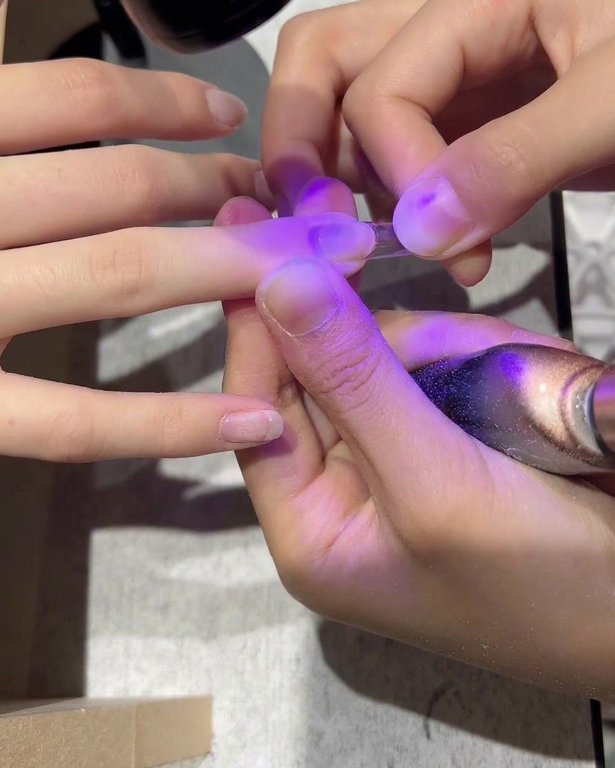 Ein transparenter Kunststoff-Nageltip, der mit Kleber auf einen Naturnagel gesetzt wird.