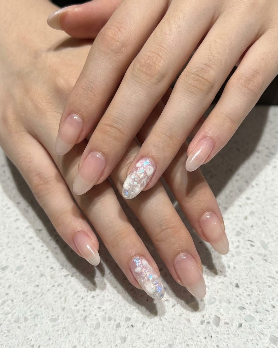 Nahaufnahme, wie ein Schwamm-Applikator weißes Gel auf einen Nude-Pink Nagel tupft.