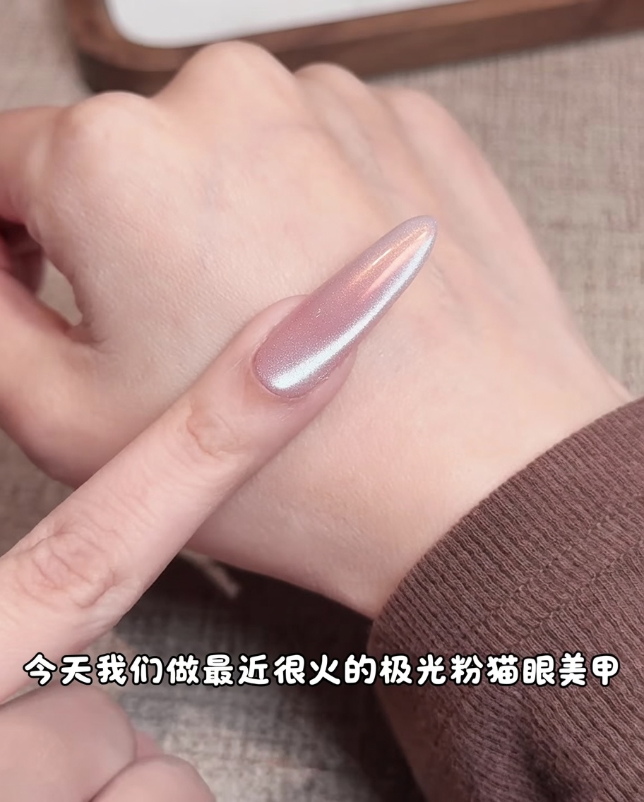 Ein Make-up-Schwamm trägt rosa Pigment auf die Mitte eines Nude-Gel-Nagels auf und erzeugt einen weichen, diffusen Farbverlauf.