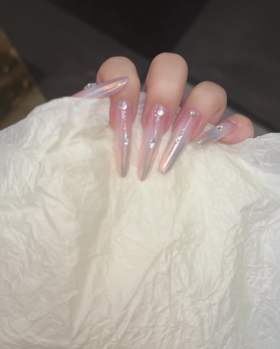 Ein Nagelpinsel fügt eine zweite Schicht Blushing-Gel hinzu, um den Verlauf zu vertiefen.