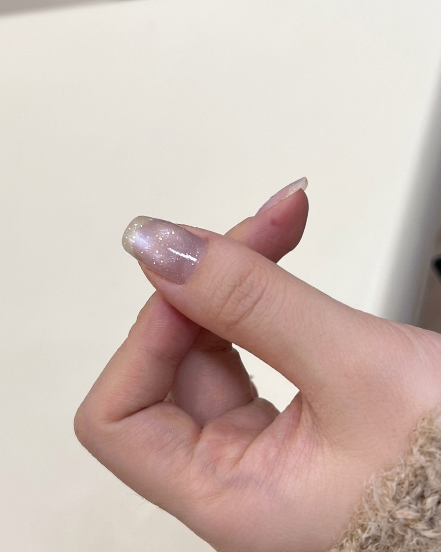 Eine Hand in einer UV-Nagellampe beim Aushärten des Cat-Eye-Gels.