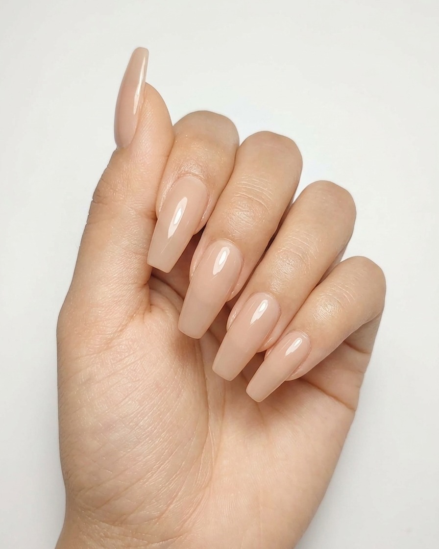 Nahaufnahme eines Nude-Nagels mit einem fertig gemalten silbernen Stern, der unter einer Lampe aushärtet.