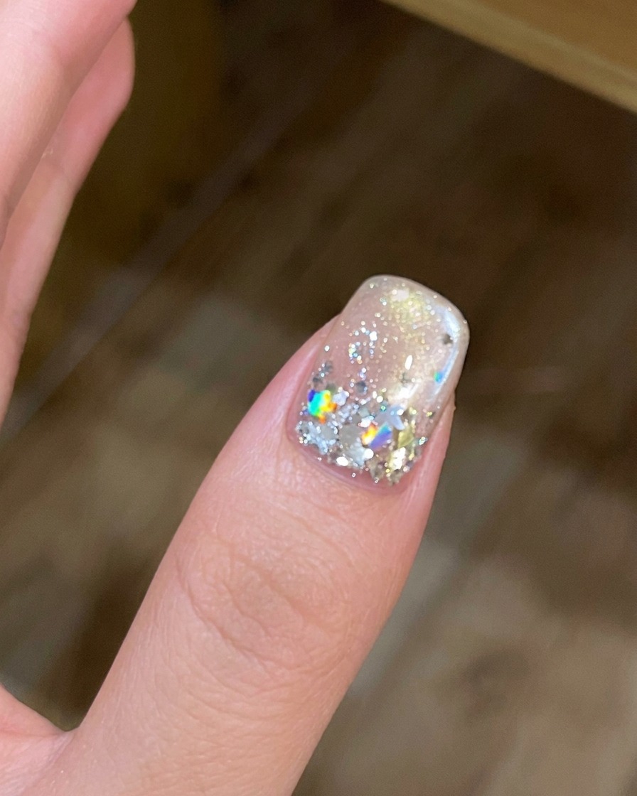 Eine Hand in einer UV/LED-Nagellampe bei aktiviertem Licht.