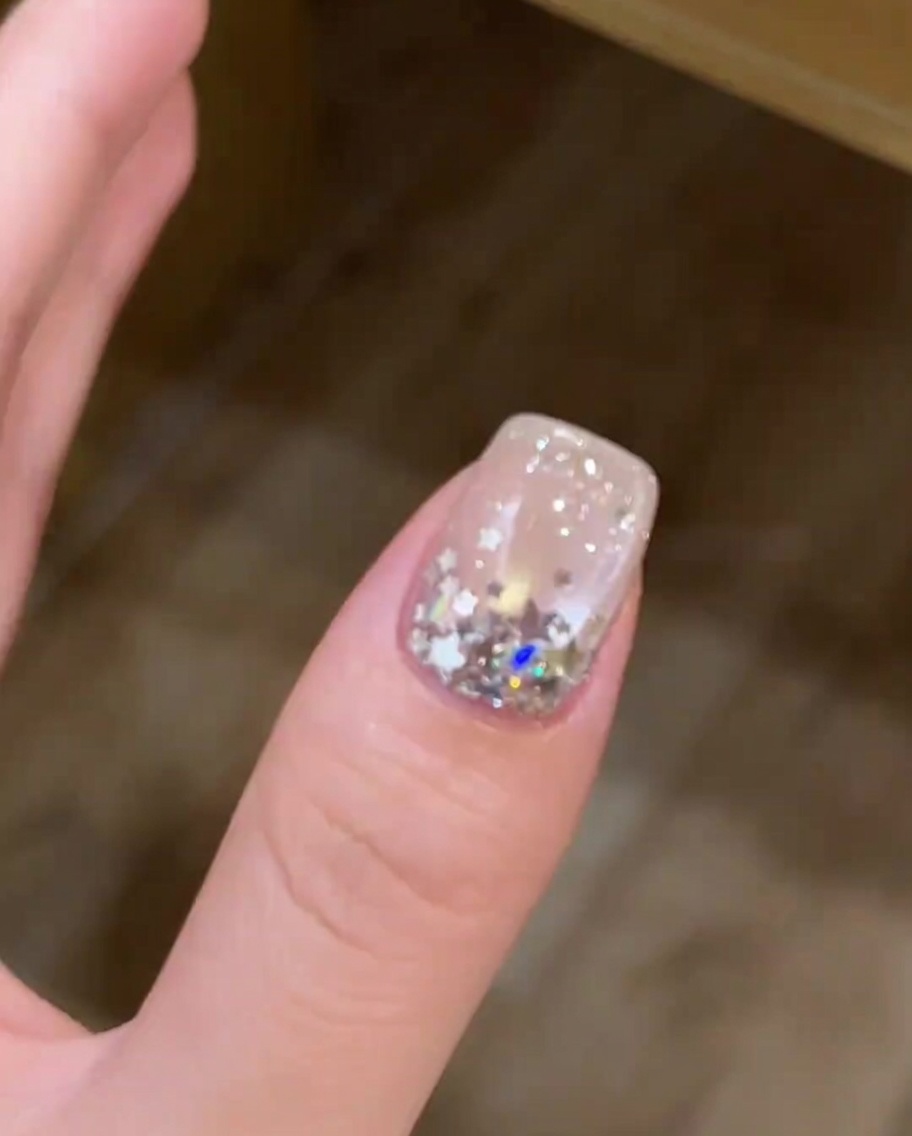 Nahaufnahme eines Nagels mit Cat-Eye-Effekt, der in einer UV/LED-Lampe aushärtet.