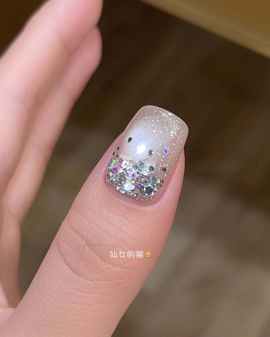 Ein Pinsel trägt eine finale Schicht glänzenden, klaren Top Coat über einen mit Sternen verzierten Nagel auf.