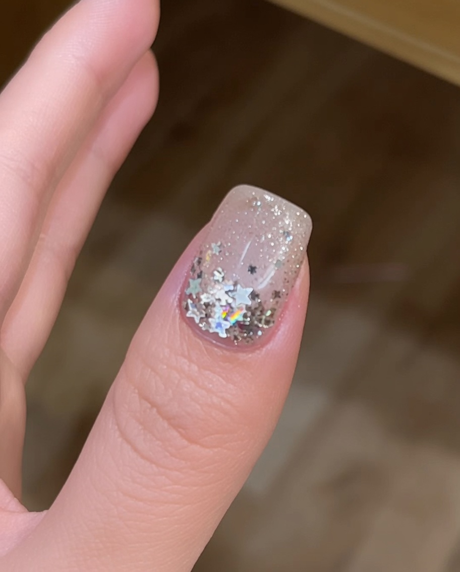 Nahaufnahme von Nägeln, die in einer UV-Lampe aushärten, was den Abschluss der Nagelmodellage markiert.