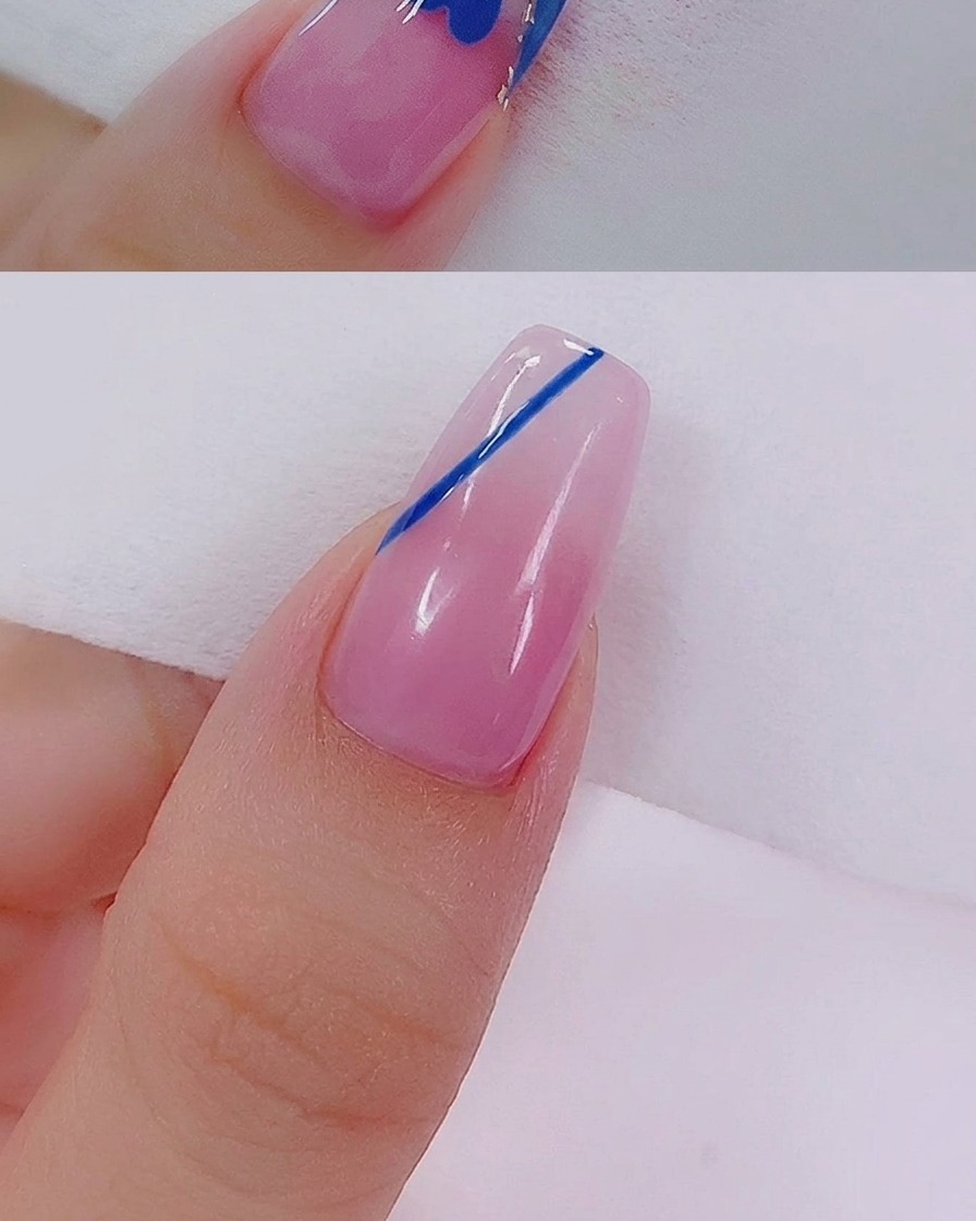 Eine Nahaufnahme einer blauen Herzform, die mit einem feinen Nailart-Liner-Pinsel mit blauem Gel ausgefüllt wird.