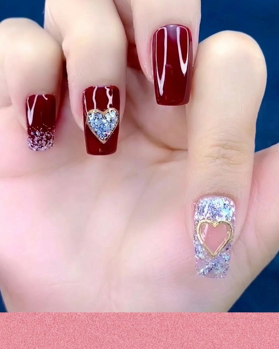 Ein Nagelhautschieber oder Silikonwerkzeug drückt auf einen Metall-Herz-Charm, der bereits auf einem Fingernagel platziert ist.