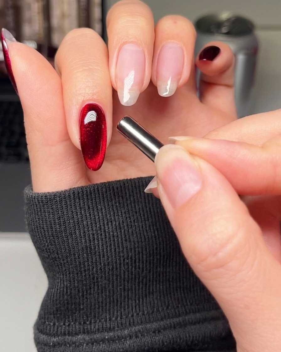 Ein Nagelpinsel trägt eine glatte Schicht schwarzes Gel auf den Zeigefinger auf.