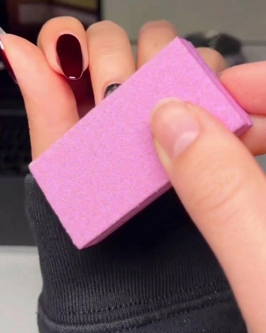 Ein dünner Liner-Pinsel umrandet ein rotes Herz präzise mit schwarzem Gel.
