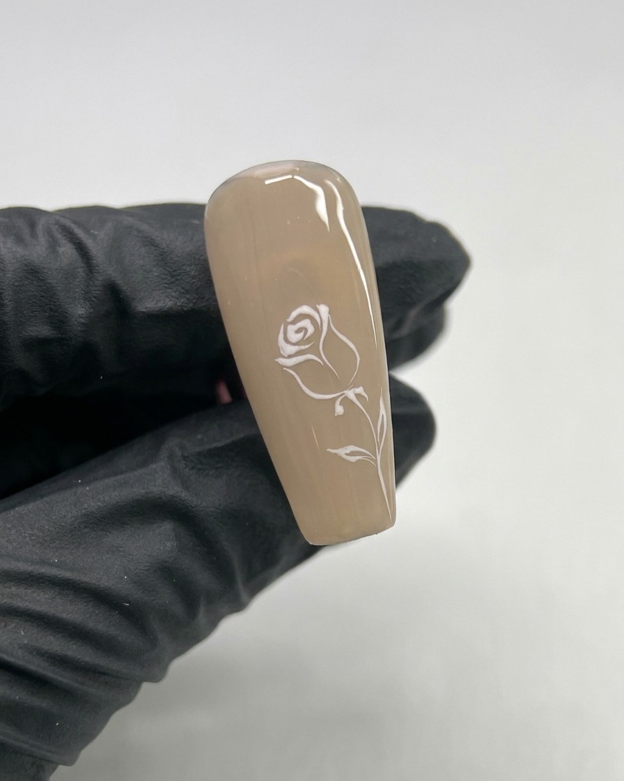 Nahaufnahme eines Nagels mit einem kleinen, in der Mitte gemalten weißen Gel-Herzen.