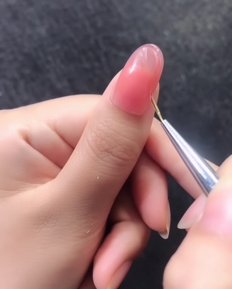 Detailansicht eines fertigen 3D-Musters aus goldenen Linien auf einem rosa Gelnagel.