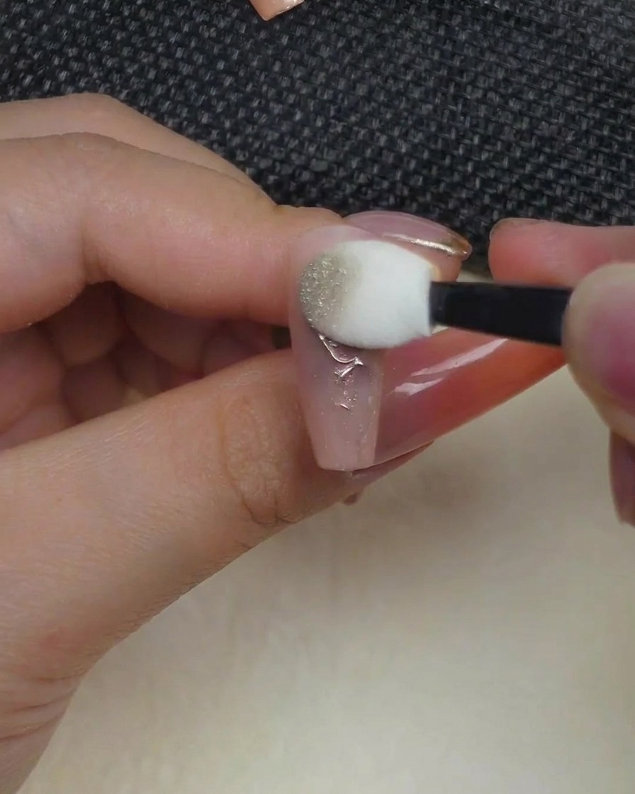 Ein Lidschatten-Applikator drückt metallisches Chrom-Puder auf das erhabene Rosen-Design.
