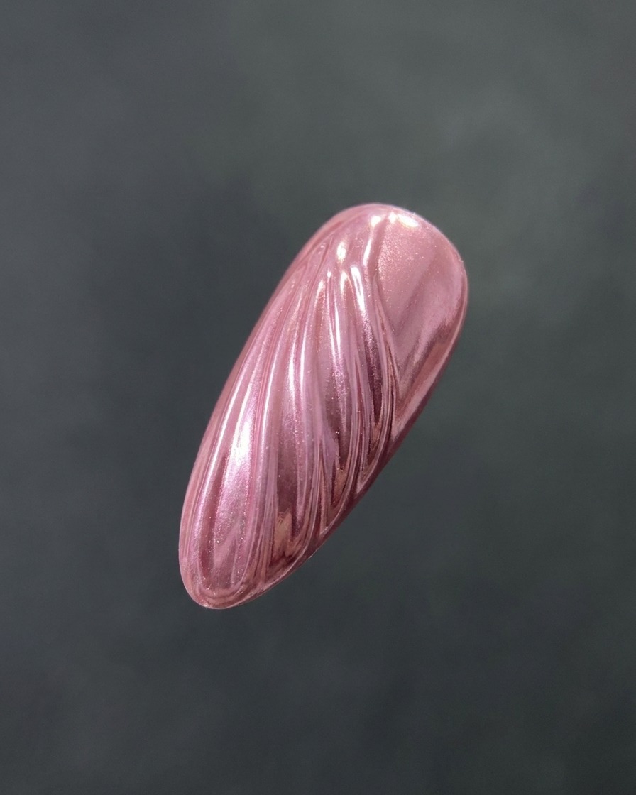 Ein Pinsel trägt einen klaren, glänzenden Top Coat über einen strukturierten, mit Chrome veredelten Nagel auf.
