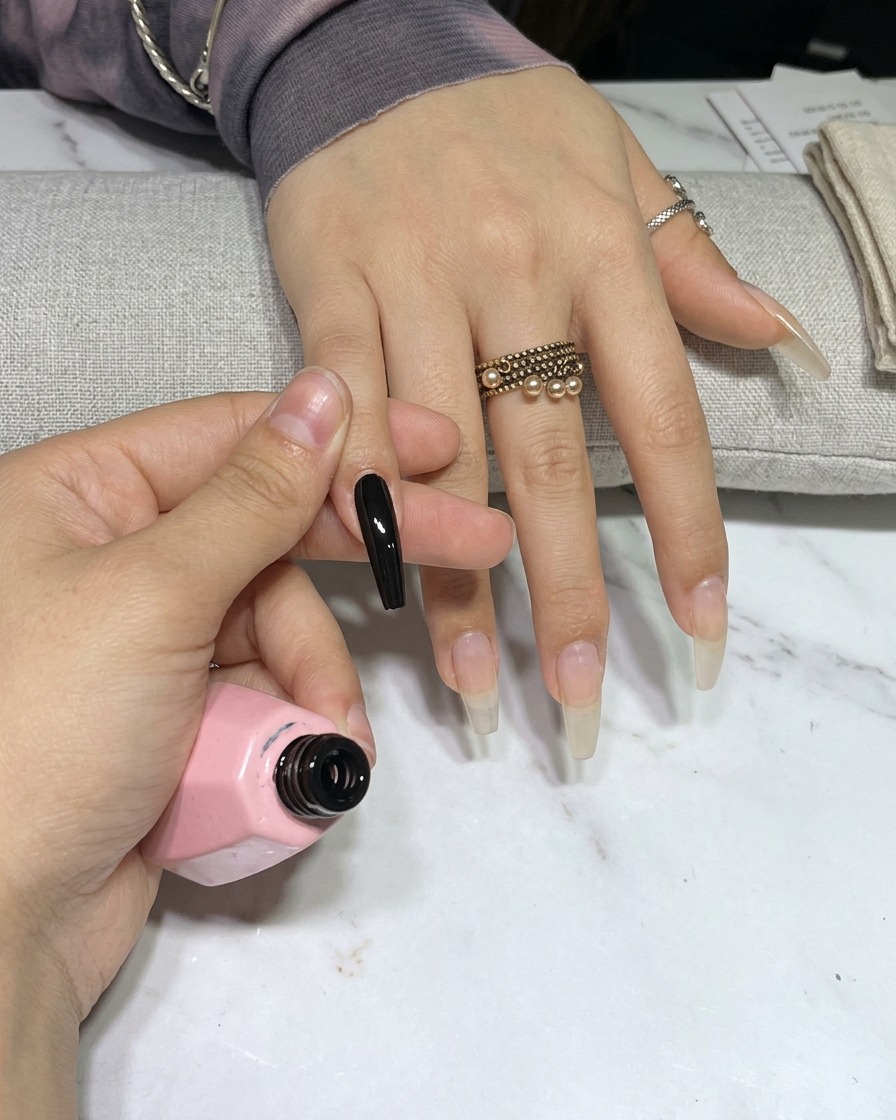Eine Hand in einer UV-Nagellampe, während die Nägel unter dem Licht aushärten.