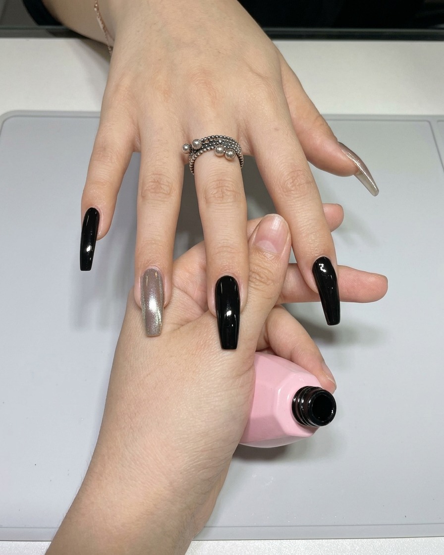 Nahaufnahme eines feinen Nail-Art-Liner-Pinsels, der schwarzes Gellack von einer kleinen Palette aufnimmt.