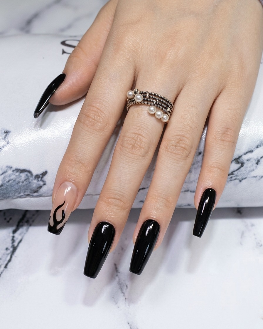 Nahaufnahme eines Liner-Pinsels, der die Kanten und Spitzen eines schwarzen Flammendesigns auf einem Chrom-Nagel schärft.