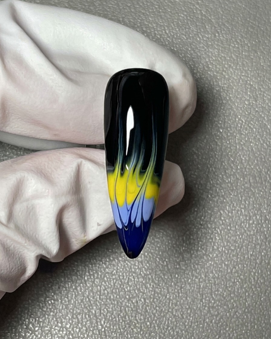 Eine Nahaufnahme eines Nagels, der vollständig mit einem glatten, deckenden schwarzen Gel-Nagellack lackiert ist.