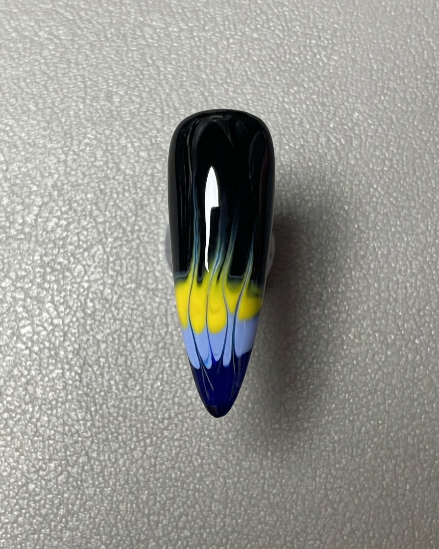 Ein horizontaler Streifen blauer Gel-Lack, der auf der Spitze des schwarz lackierten Nagels aufgetragen wurde.