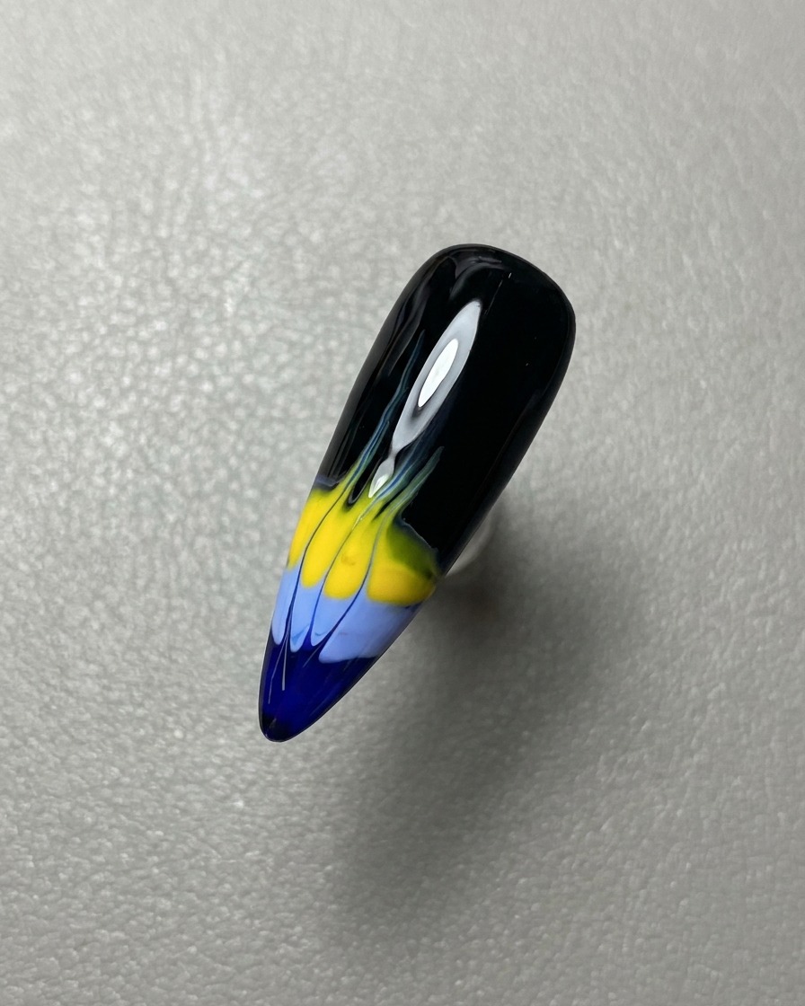 Ein Pinsel, der eine Schicht klaren, glänzenden Gel-Überlacks über das fertige Flammen-Nageldesign aufträgt.