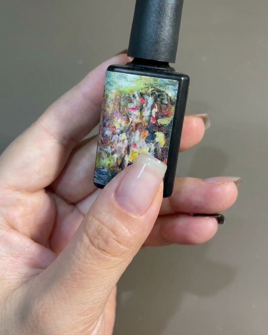 Ein Pinsel trägt eine gleichmäßige Schicht schwarzen Gel-Lacks auf einen Naturnagel auf.