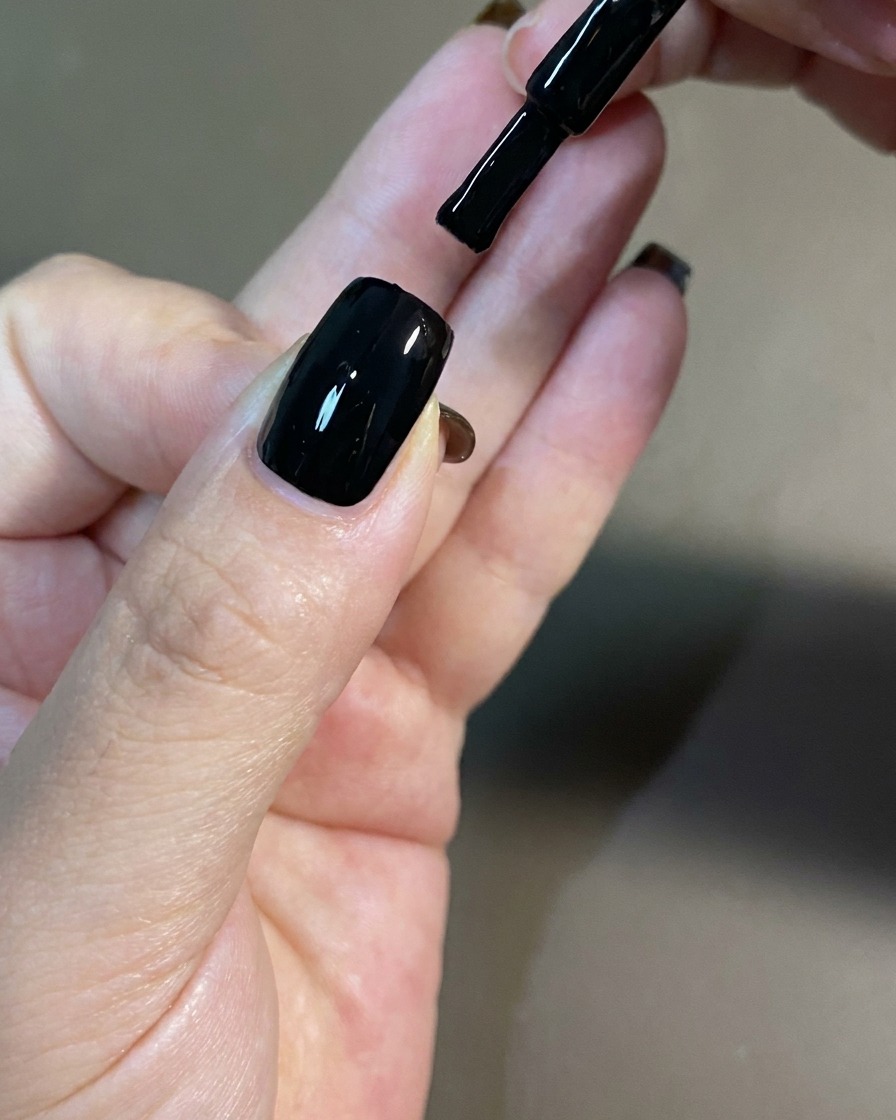 Eine Hand liegt zum Aushärten in einer professionellen UV-Nagellampe.