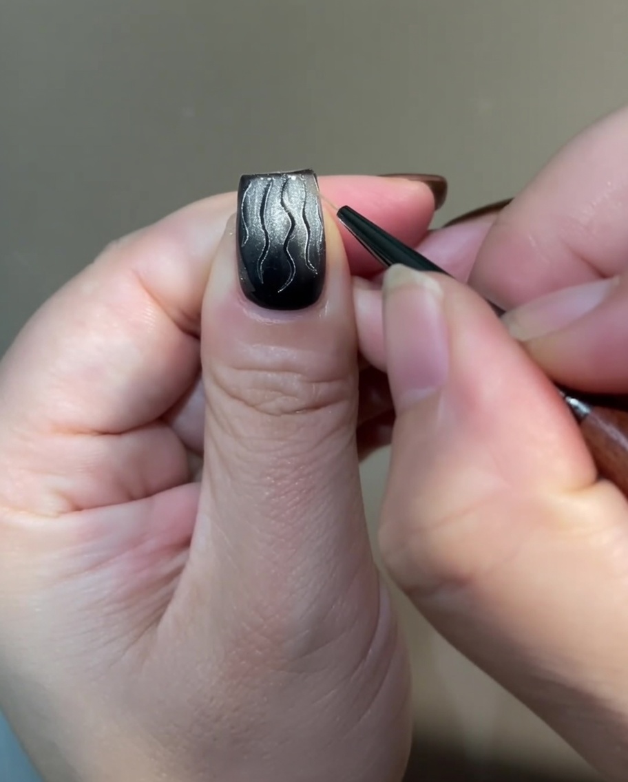 Eine Detailansicht, die zeigt, wie die Basis der Flammenkunst mit dünnen, kreuzschraffierten Linien mit einem Liner-Pinsel verbunden wird.