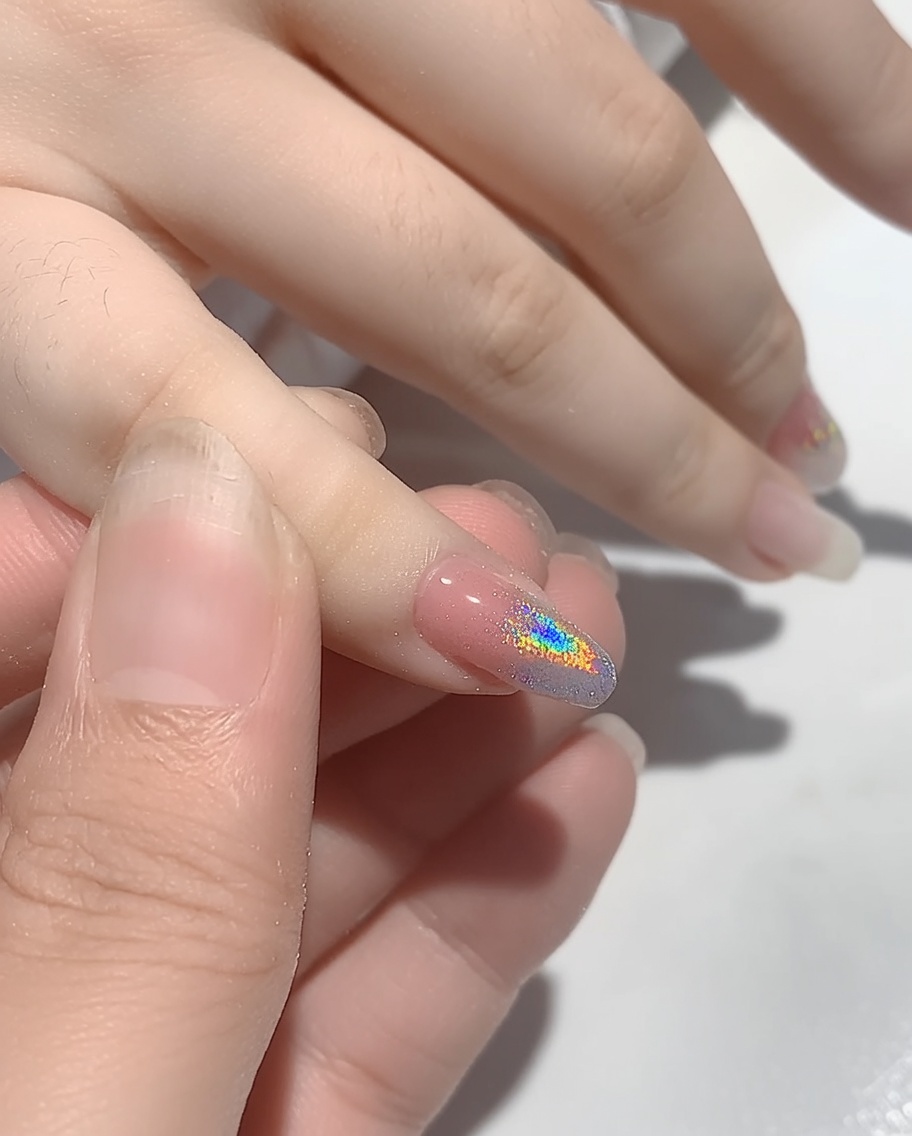 Eine Hand in einer UV-Nagellampe, um das aufgetragene Puder auszuhärten.