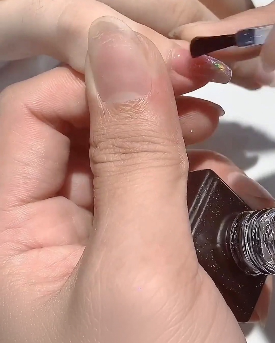 Die Hand ruht in der UV-Lampe, während die Nägel aushärten.