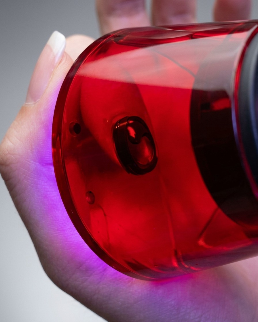 Nahaufnahme einer Hand, die eine kompakte UV/LED-Lampe direkt über einen Finger hält, um das aufgetragene Gel auszuhärten.