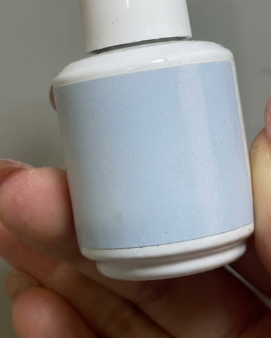 Ein Pinsel trägt einen klaren matten Überlack über die Nude-Gelschicht auf.
