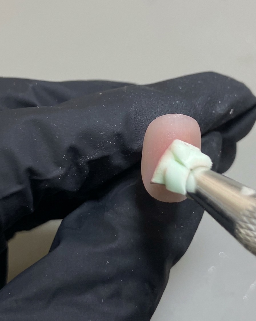 Nahaufnahme eines Nagels, bei dem ein Schwämmchen den rosa Punkt zu einem Ombré-Verlauf verblendet.